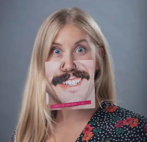 An employee having fun and wearing a funny face mask that has a smiling mouth on it